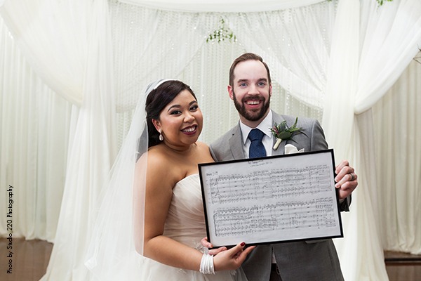 Couple holding custom wedding sheet music