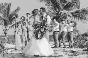 Bride and groom kiss on the beach after wedding