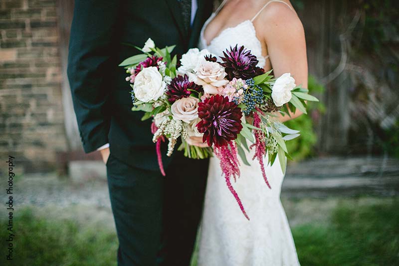 Bridal bouquet with assorted blush and maroon flowers with greenery