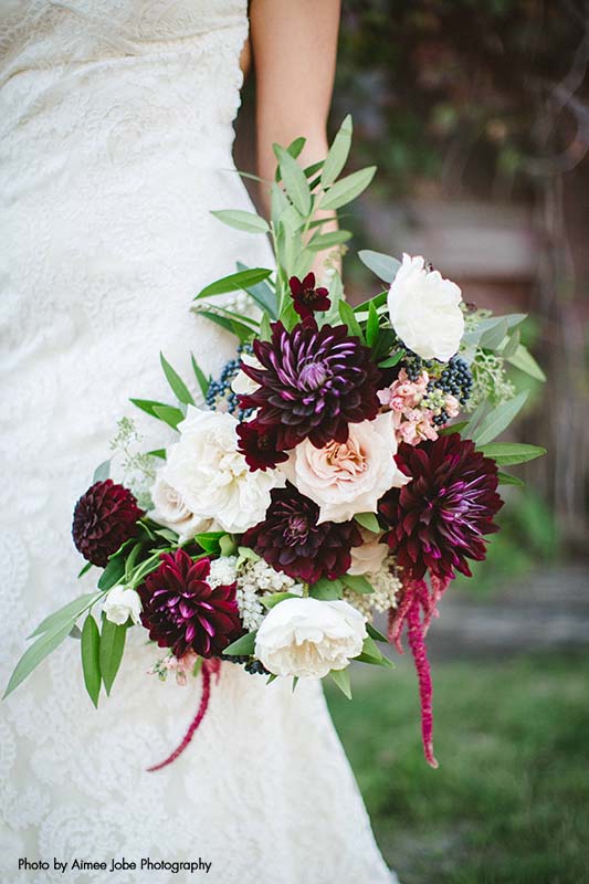 Bridal bouquet with assorted white and maroon flowers with greenery