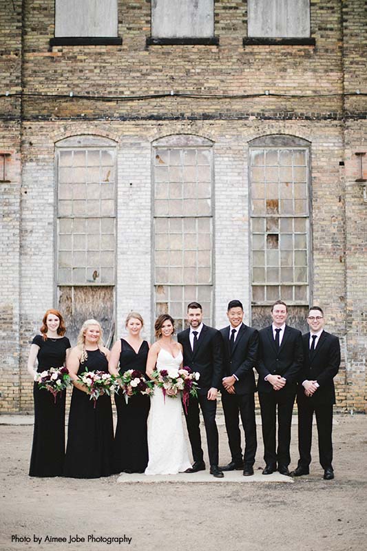 Wedding party in black dresses and black and white tuxedos