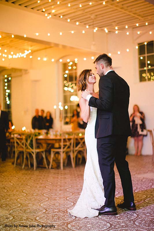 Elegant first dance with string lights lighting up the room