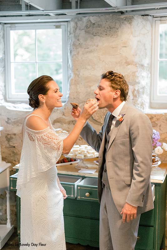 Bride and groom feeding each other cake after cutting it