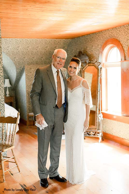 Father of the bride in a grey suit and the bride in a boho dress before the wedding ceremony