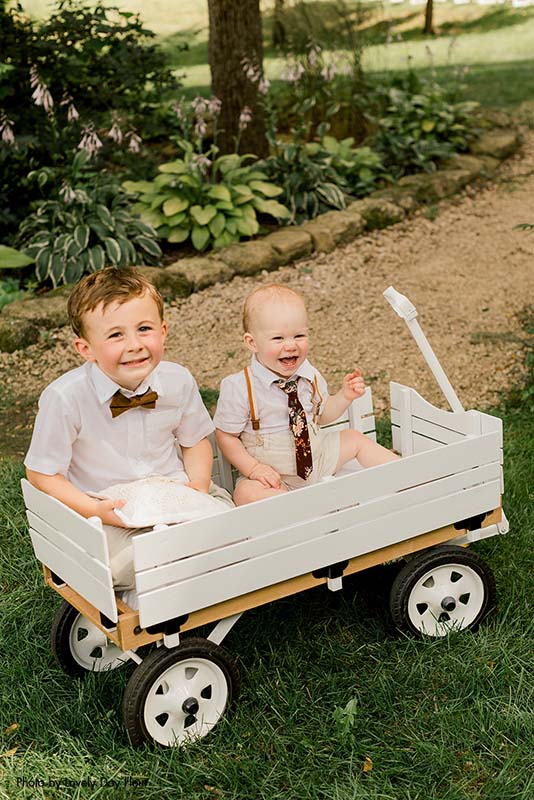 Ring bearers posing in a wagon before the ceremony