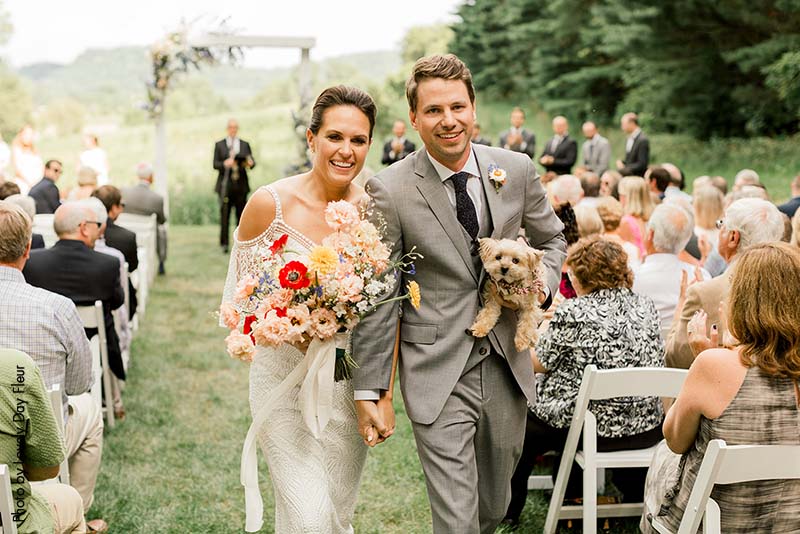 Bride and groom leave ceremony with dog