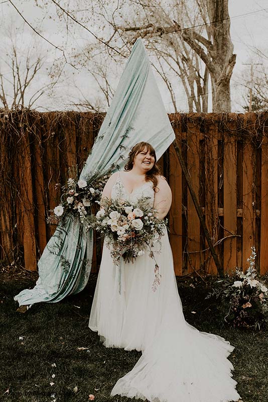 Bride stands in front of blue triangle backdrop
