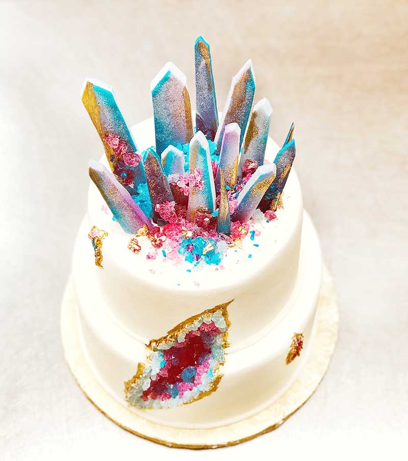White wedding cake with rainbow geode and crystals