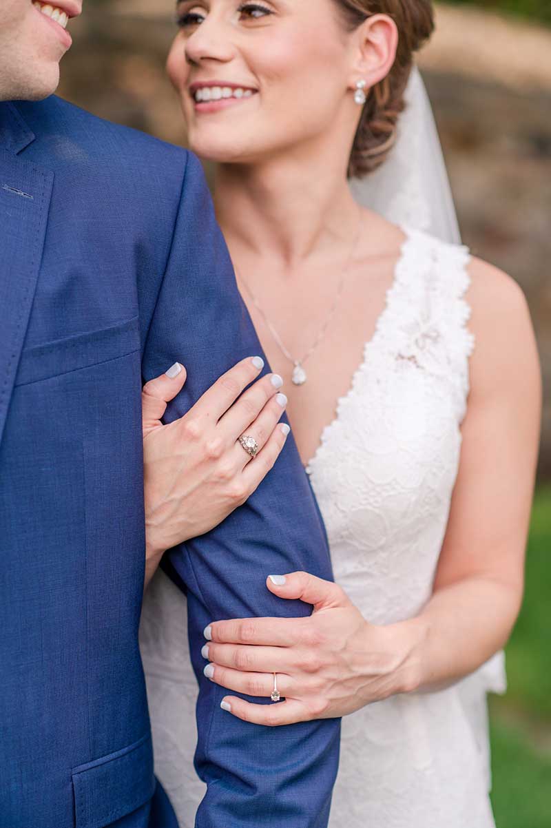 Bride wearing a white dress and groom in a blue suit post ceremony