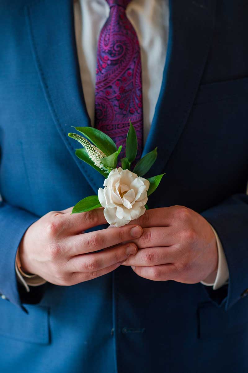 White rose boutonniere with greenery
