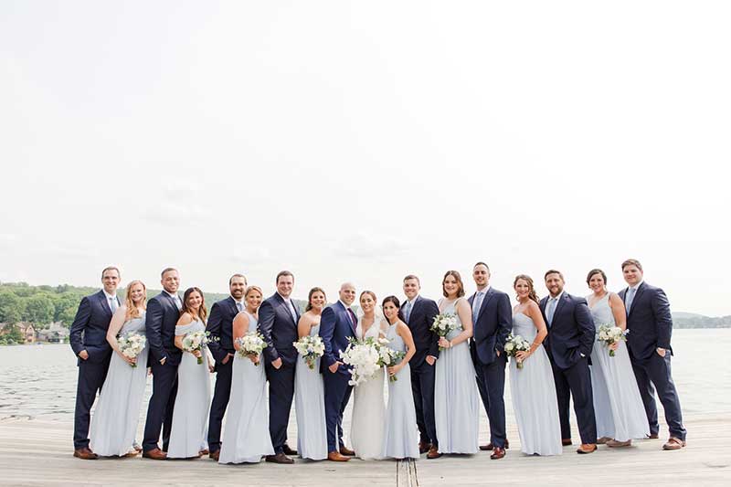 Wedding party in blue formalwear stands on deck