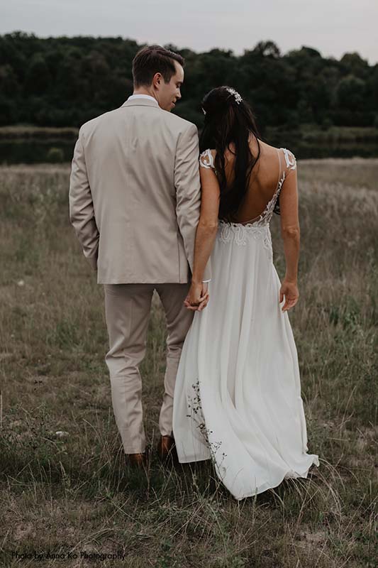 Bride and groom pose for moody outdoor photo