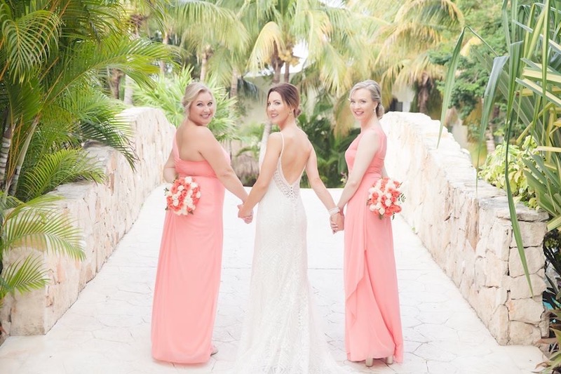 Bride with bridesmaids in coral dresses before destination wedding