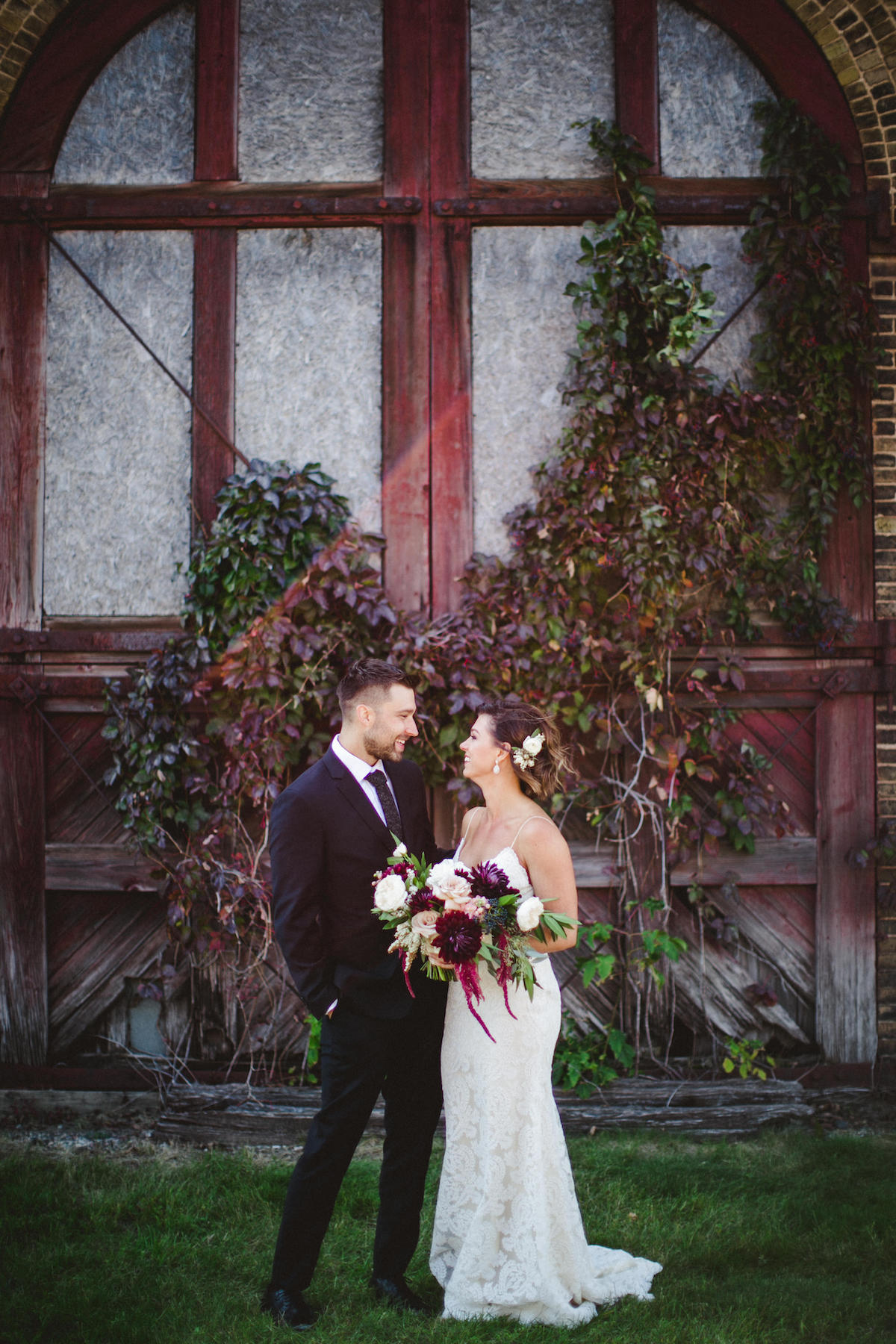 Bride and groom stand outside reclaimed train station for an industrial chic wedding