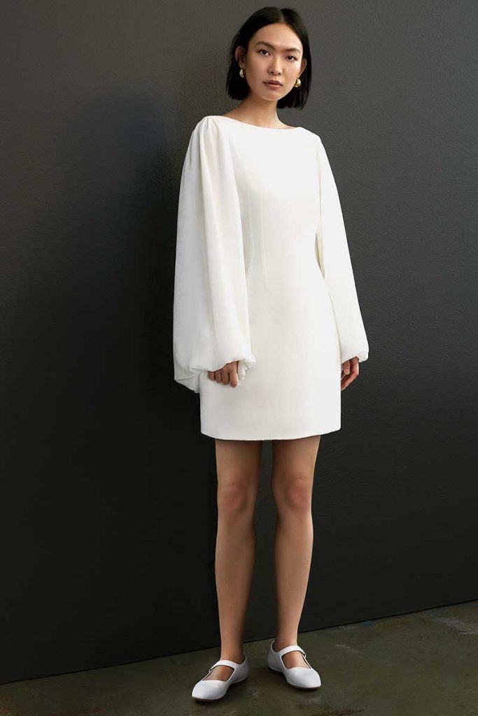 Long-sleeved white mini bridal dress by Savannah Miller
