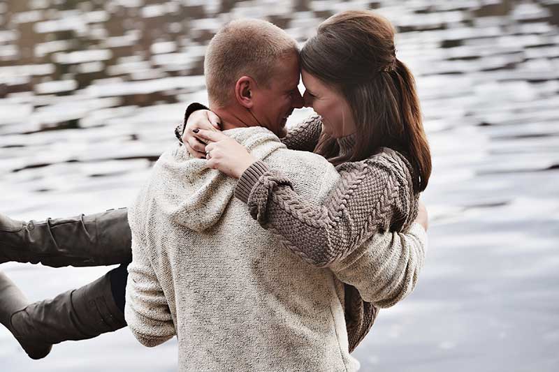 Couple takes engagement photos by lake