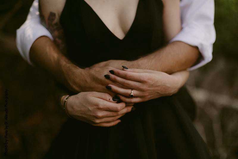 Moody photo of bride and groom holding hands