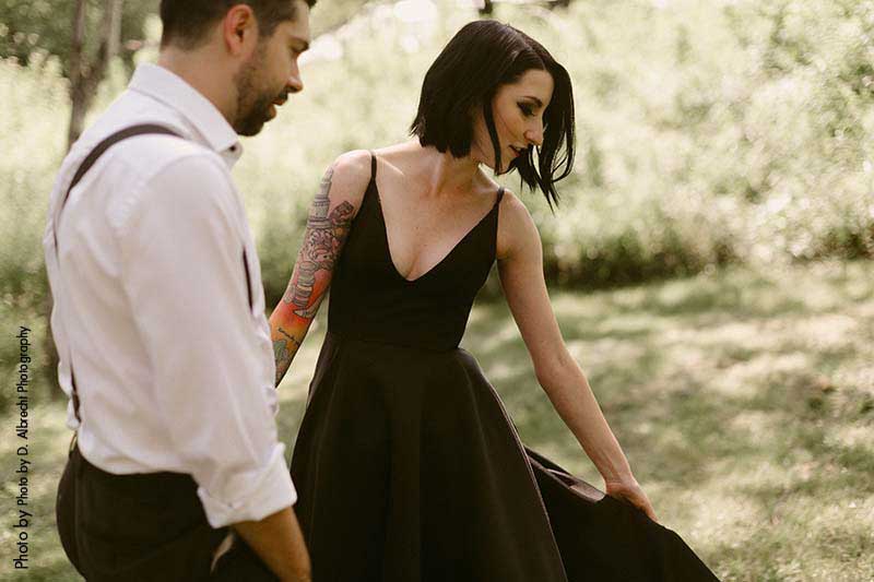 Bride in black wedding dress and groom in suspenders