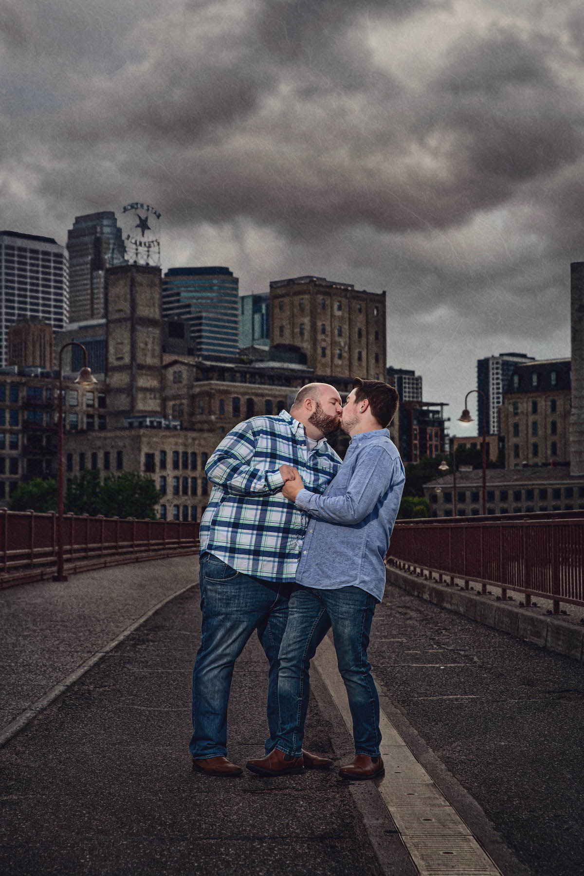 Couple kisses on the Stone Arch Bridge in Minneapolis
