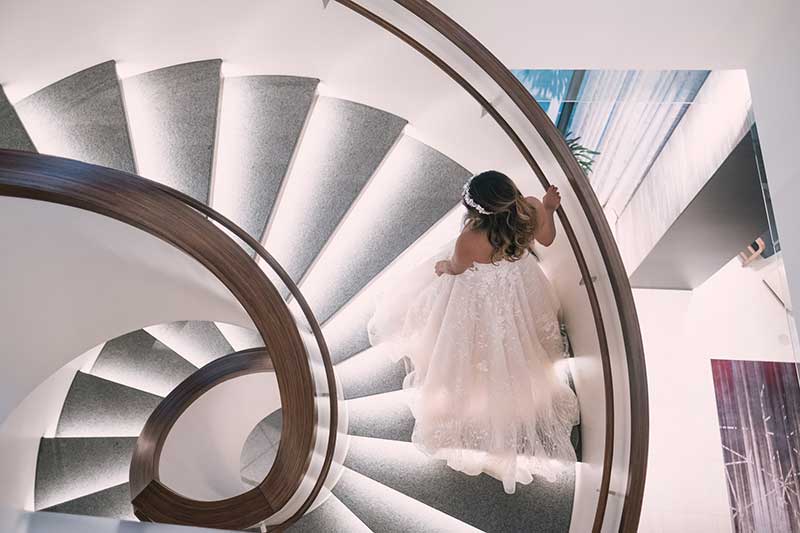 Bride walks up spiral stairs at luxury wedding venue J. Powers