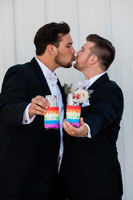 grooms hold rainbow-striped coozies that that say "Mr."