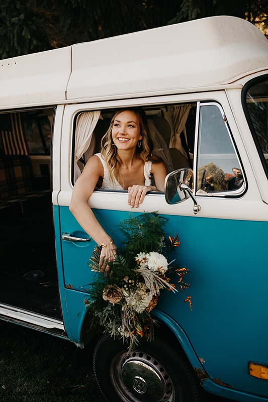 Bride sits in blue Volkswagen van
