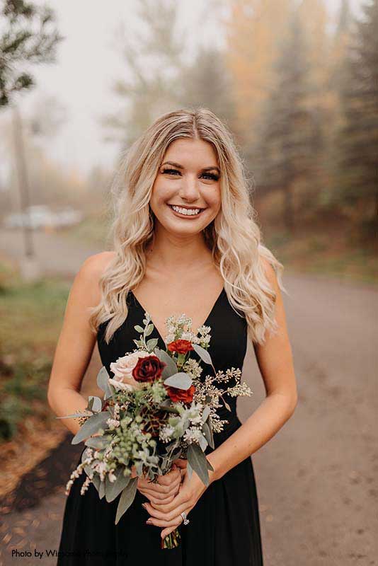 Bridesmaid in black dress an fall bouquet