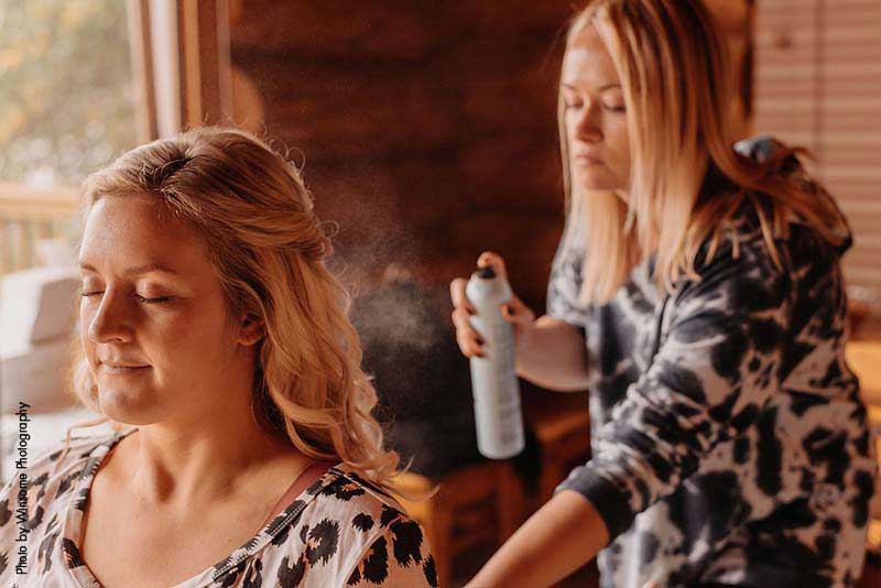 Bride gets hair done in cabin on morning of the wedding