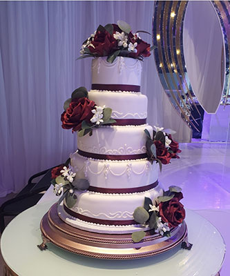 5-tier white wedding cake with red roses by Sweet Assuance