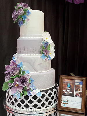5-tier wedding cake with purple and blue sugar flowers