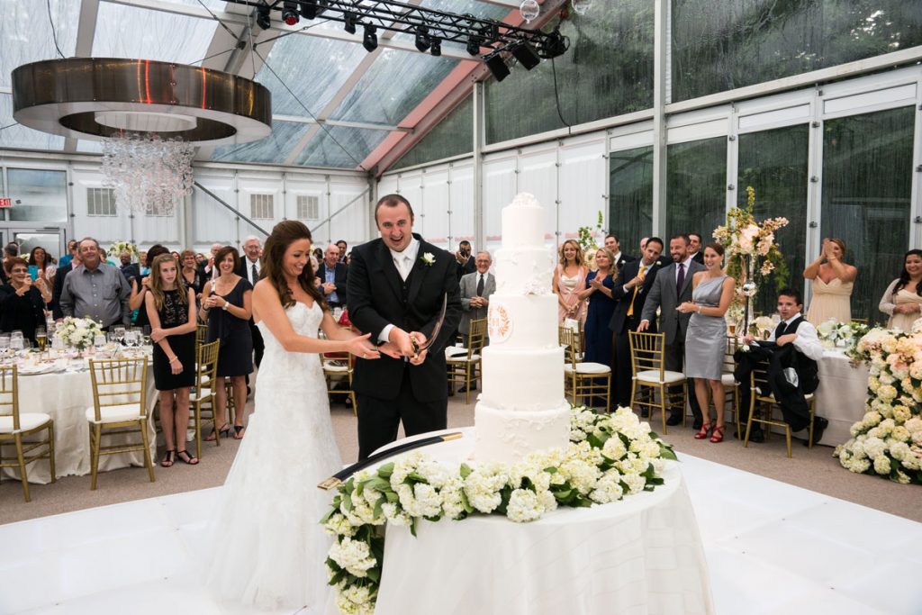 Bride and groom cut 5 food wedding cake with Lebanese sword