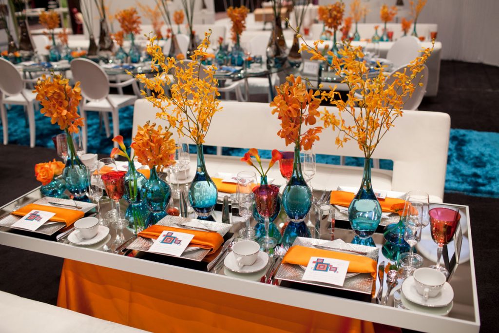 Mirrored-top head table with bulbous blue vases and orang eflower s