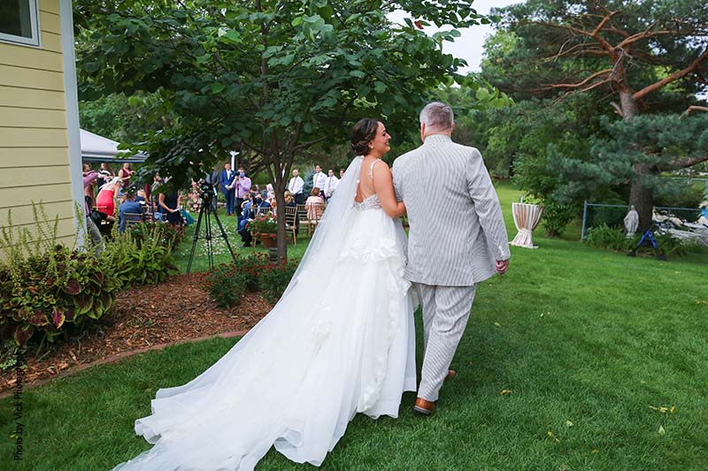 Father walks bride down the aisle at backyard wedding