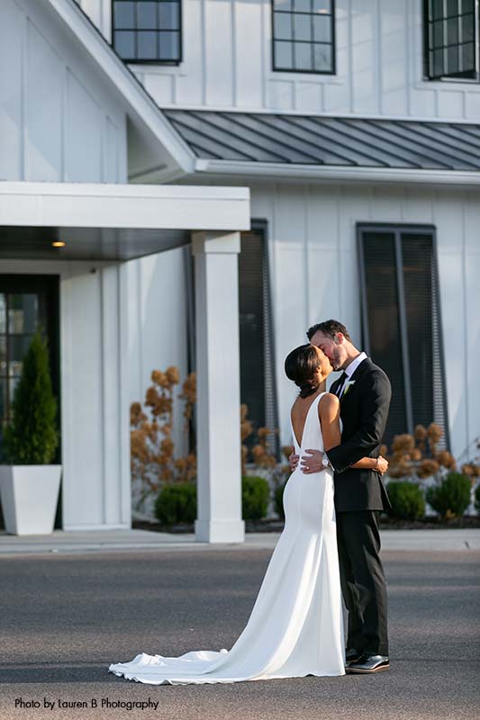 Bride and groom kiss outside of The Hutton House