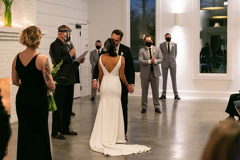 Bride and groom share first kiss at modern micro wedding