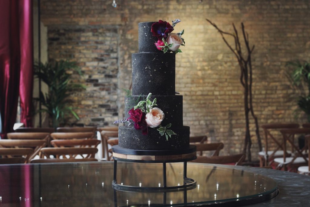 Black wedding cake with pink and red flowers