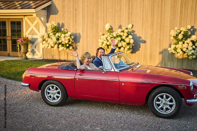 Bride and groom in vintage red convertible