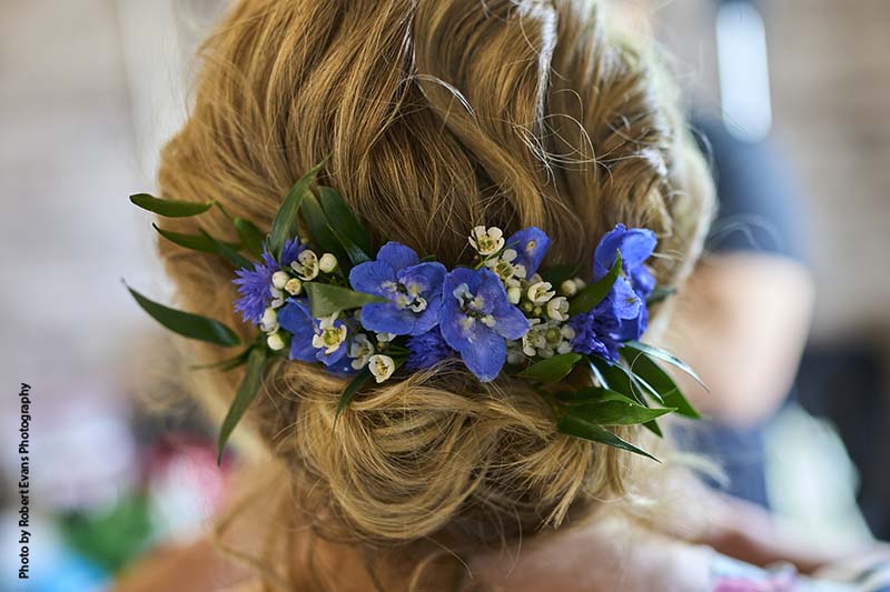 Bridal headpiece with bright blue floral and greenery
