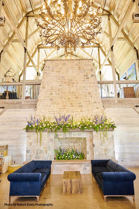 Wedding lounge by fireplace with greenery and floral