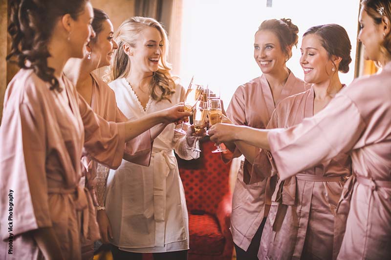 Bride and bridesmaids toast in bridal suite