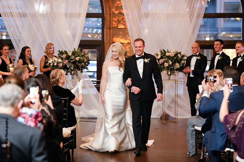 Bride and groom walk down aisle after wedding