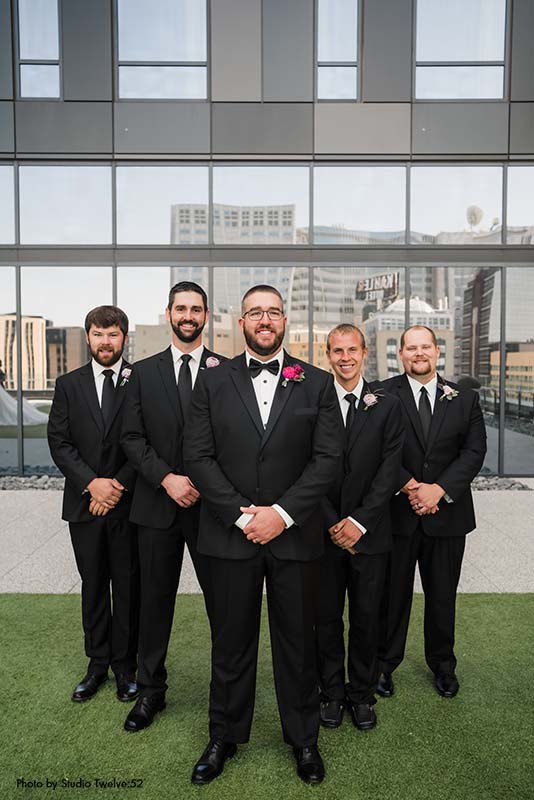 Groom and groomsmen in black suits and ties