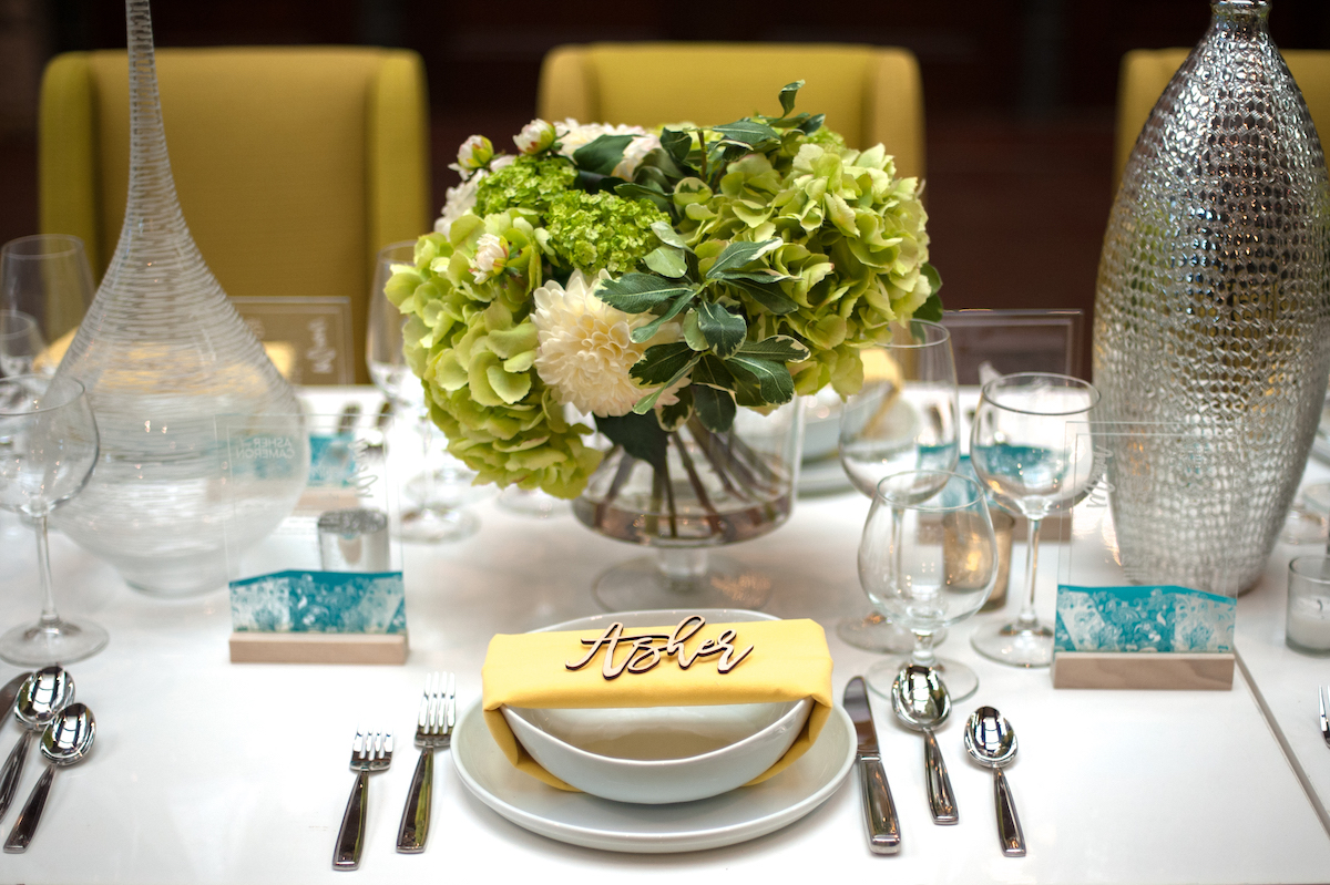 Wedding tabletop with white dishes and yellow napkin