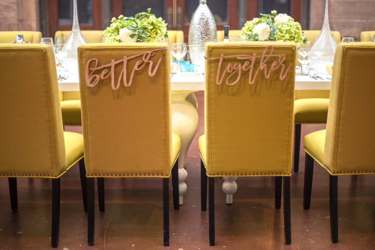 Green wedding chairs with laser cut letters that say "Better Together" 