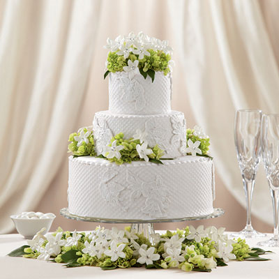 3-tier white wedding cake with green and white flowers