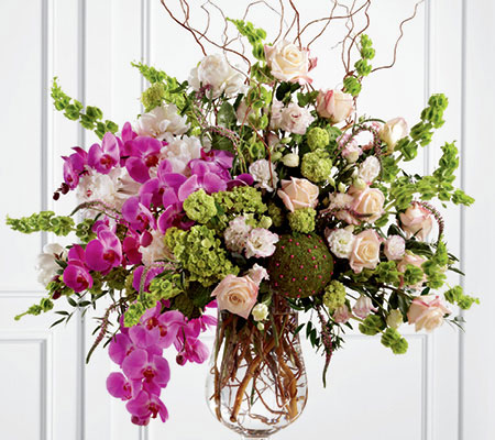 Whimsical wedding centerpiece with branches and purple orchids