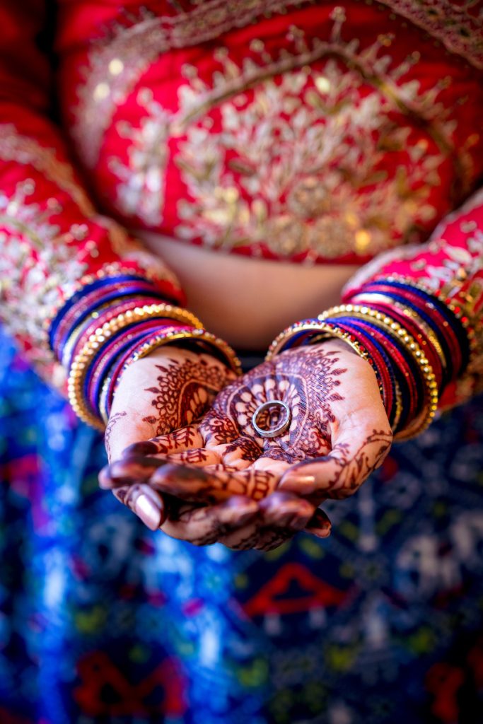 Indian bride holds wedding rings in her hands
