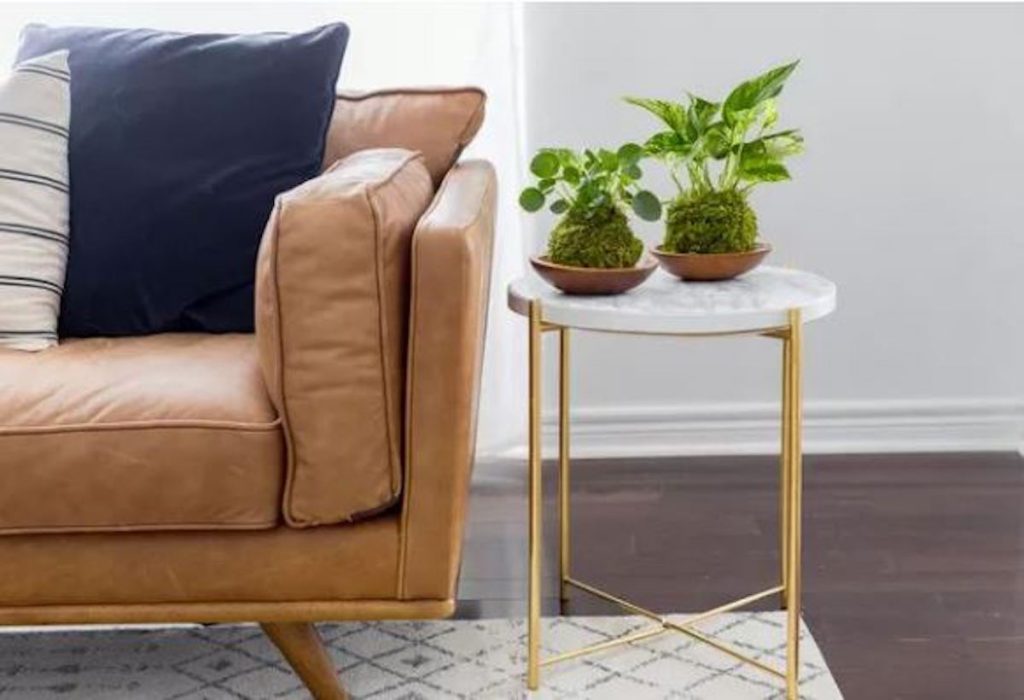 Buying your first home together choosing leather sofa couch and gold and marble side table