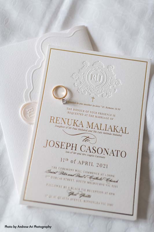 Traditional white wedding invitation with gold text