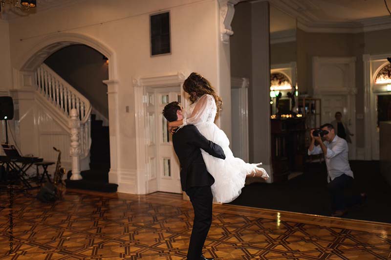 Bride and groom swing dance during wedding reception